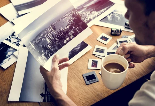 Mann mit Kaffee und Fotos — Stockfoto