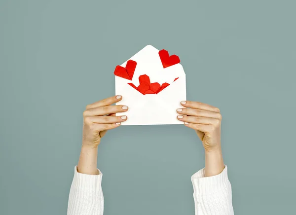 Femme tenant l'enveloppe avec des coeurs — Photo