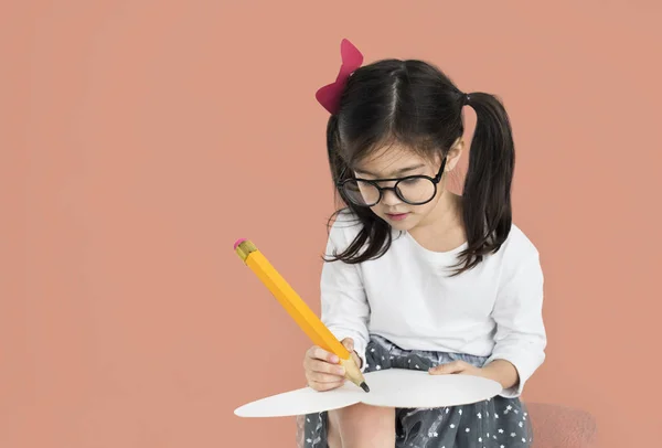 Meisje met grote potlood schrijven — Stockfoto