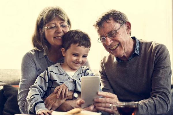 Nonni con smartphone di navigazione nipote — Foto Stock