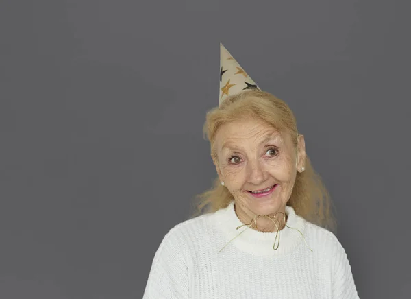 Mulher Sênior usando chapéu de festa — Fotografia de Stock