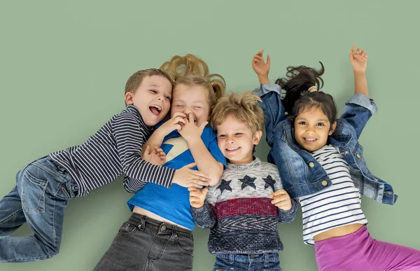 Niños multiétnicos tendidos en el suelo —  Fotos de Stock