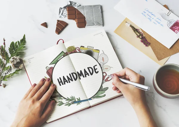 Woman drawing sketches in open notebook