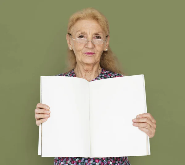Mujer mayor mostrando libro vacío — Foto de Stock