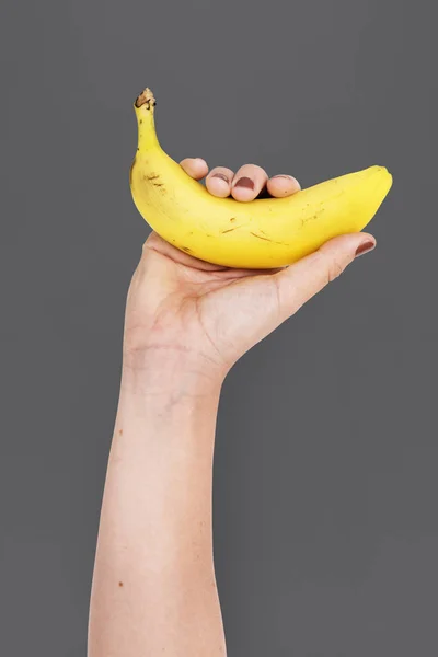 Lidská ruka hospodářství banán — Stock fotografie