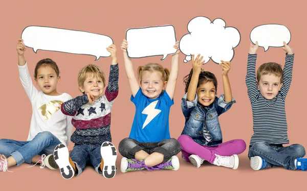 Niños sosteniendo burbujas del habla —  Fotos de Stock