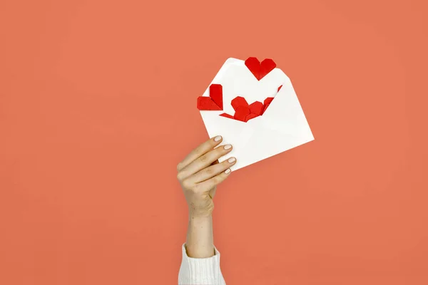Женщина держит конверт с сердцами — стоковое фото