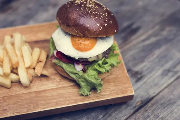 Hamburguesa y papas fritas en la mesa — Foto de Stock