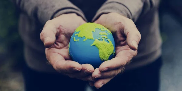Händer som håller lilla jorden planet — Stockfoto