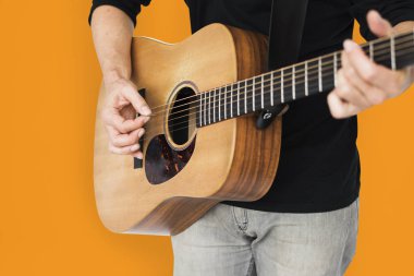 Adam akustik gitar çalıyor.