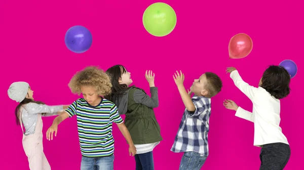 Niños jugando con globos de colores —  Fotos de Stock