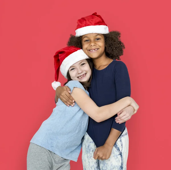 Crianças felizes vestindo chapéus de Santa — Fotografia de Stock