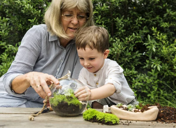 Mormor plantera växter med barnbarn — Stockfoto