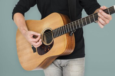 Adam akustik gitar çalıyor.