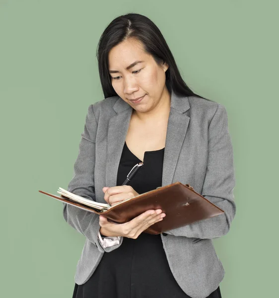 Asian businesswoman writing in diary — Stock Photo, Image