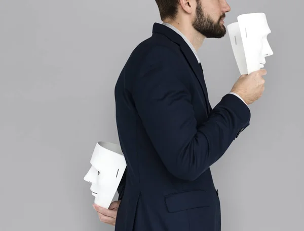 Businessman holding masks — Stock Photo, Image