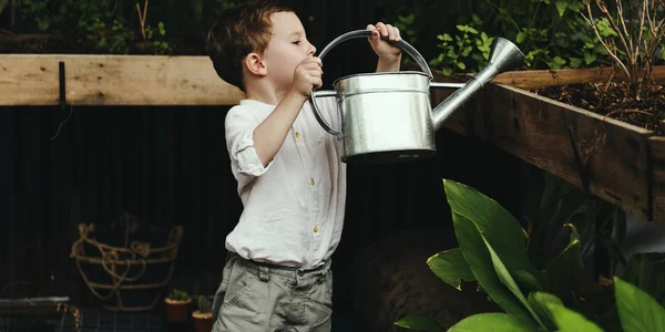 Menino rega plantas de jardim — Fotografia de Stock