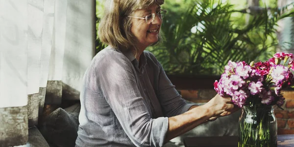 Mulher sênior com flores — Fotografia de Stock