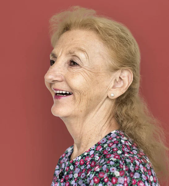 Äldre kvinna ler i studio — Stockfoto