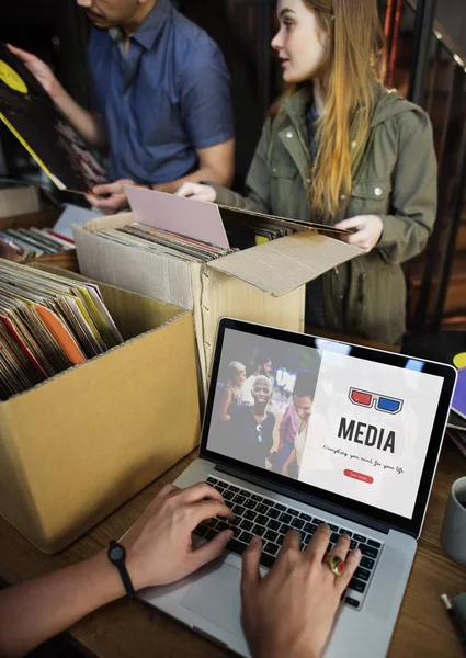 Homem na loja de vinil usando laptop — Fotografia de Stock