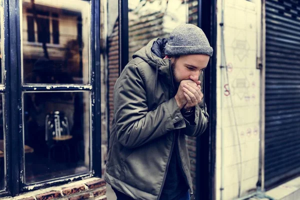 Ragazzo soffiando la sua mani in freddo — Foto Stock