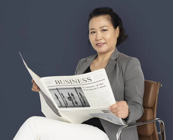 Азиатская деловая женщина с газетой в руках — стоковое фото