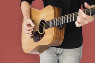 Adam akustik gitar çalıyor.