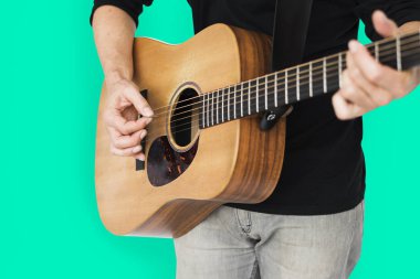 Adam akustik gitar çalıyor.