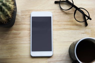 Smartphone, fincan kahve ve gözlük