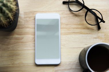 Smartphone, fincan kahve ve gözlük