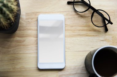 Smartphone, fincan kahve ve gözlük