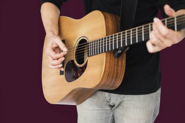 Adam akustik gitar çalıyor.
