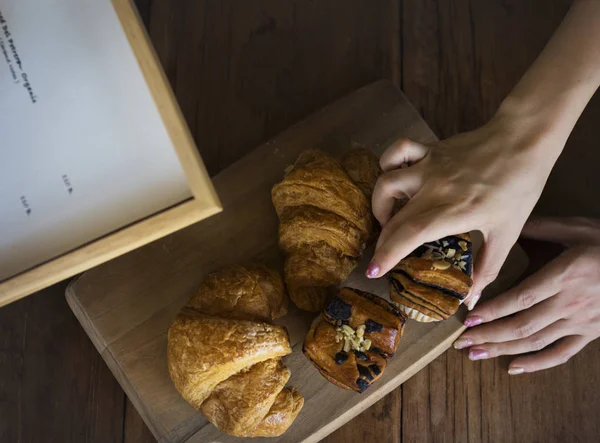 Hands of girl touching loafs of bread — Stock Photo, Image