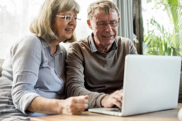 Ηλικιωμένο ζευγάρι που χρησιμοποιεί φορητό υπολογιστή — Φωτογραφία Αρχείου