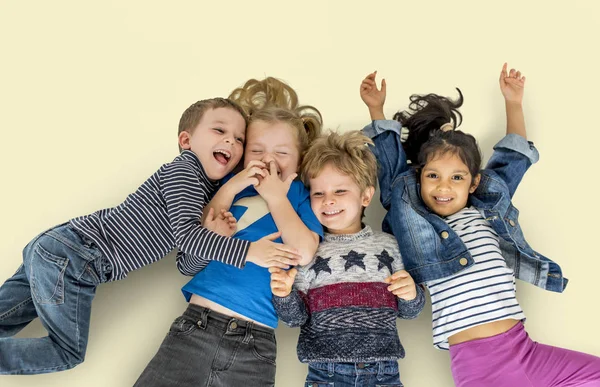 Niños multiétnicos tendidos en el suelo —  Fotos de Stock