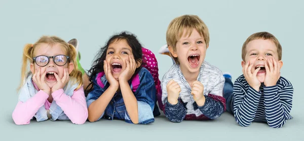 Niños multiétnicos tendidos en el suelo — Foto de Stock