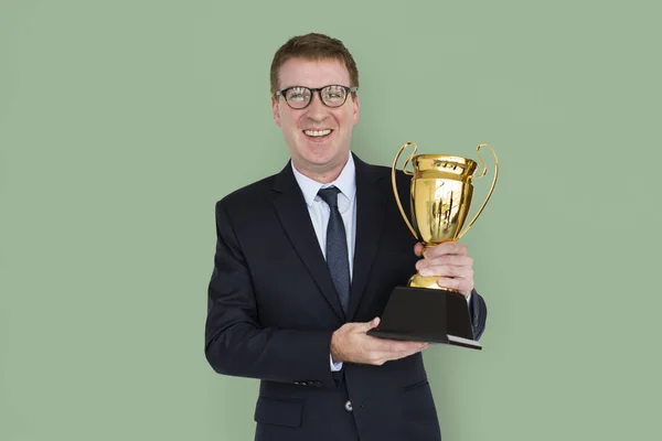 Empresario sosteniendo trofeo dorado —  Fotos de Stock