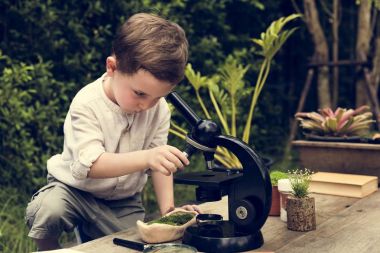 Küçük çocuk mikroskopla deneme