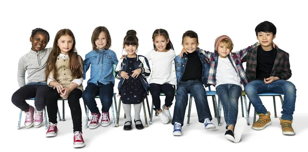 Enfants assis sur des chaises en studio — Photo