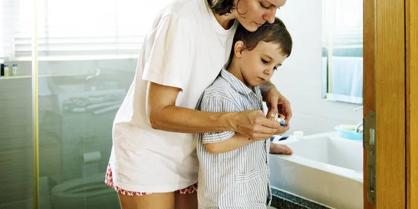 Madre enseñando hijo a cepillarse los dientes — Foto de Stock