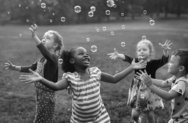 Barn som leker med såpbubblor — Stockfoto