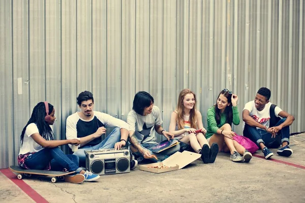 Friends talking while sitting by wall — Stock Photo, Image