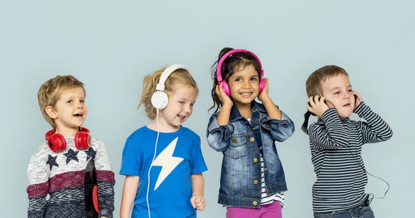 Niños escuchando música en auriculares —  Fotos de Stock