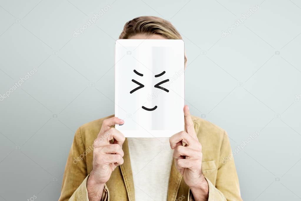 Man covering face with digital tablet