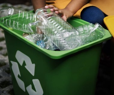 Kadının yanına kutu plastik şişe dolu