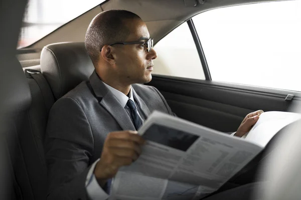 Empresário lendo jornal dentro do carro — Fotografia de Stock