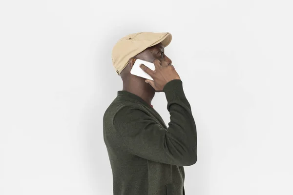 Man in cap talking on mobile — Stock Photo, Image