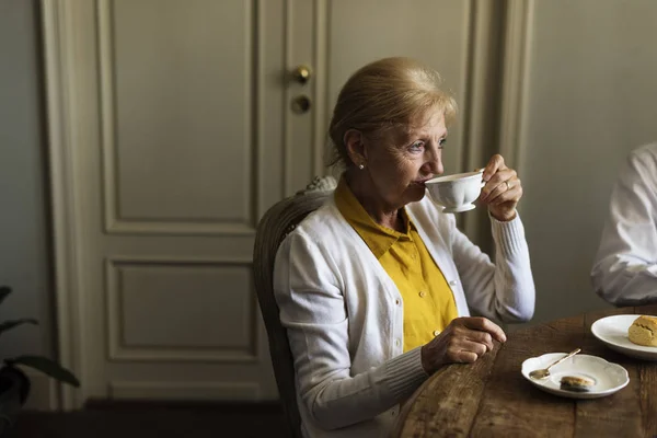 Starsza kobieta pije herbatę. — Zdjęcie stockowe