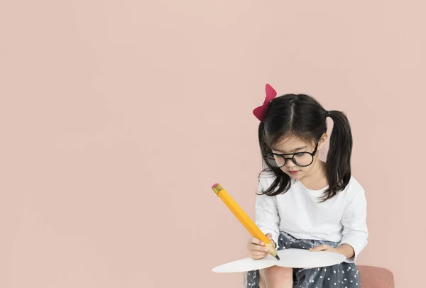 Meisje met grote potlood schrijven — Stockfoto
