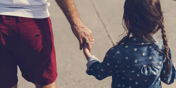 Батько і дочка тримаються за руки — стокове фото